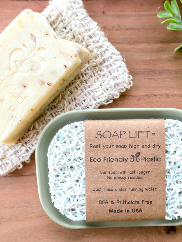 White soap lift on green dish sitting on wood background